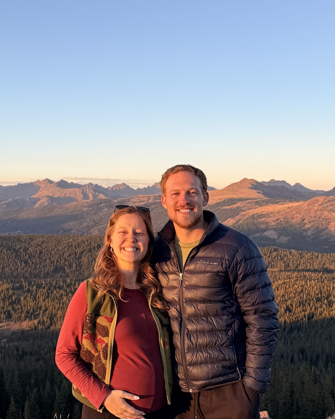 Matt Smith and his wife at sunset on a mountain summit